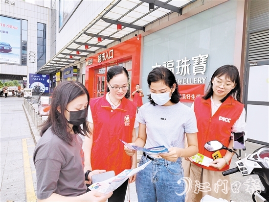 恩平人保財險工作人員向群眾派發(fā)宣傳折頁，普及金融知識。