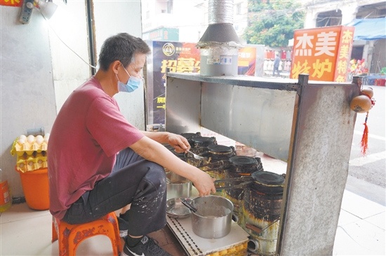店鋪老板正在烤制爐底糍。