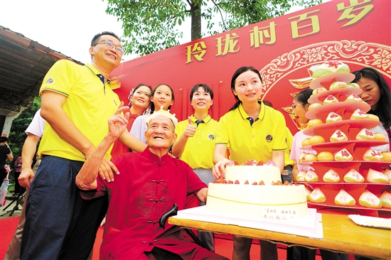 董淑猛（前排左一）、徐娜（豎大拇指者）等人為梁如旺老人慶祝百歲生日。