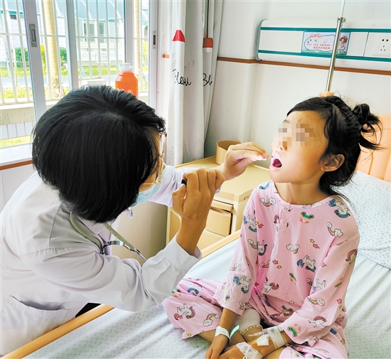 兒科醫(yī)生為手足口病患兒檢查身體情況。