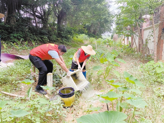 工作人員清理環(huán)境積水。