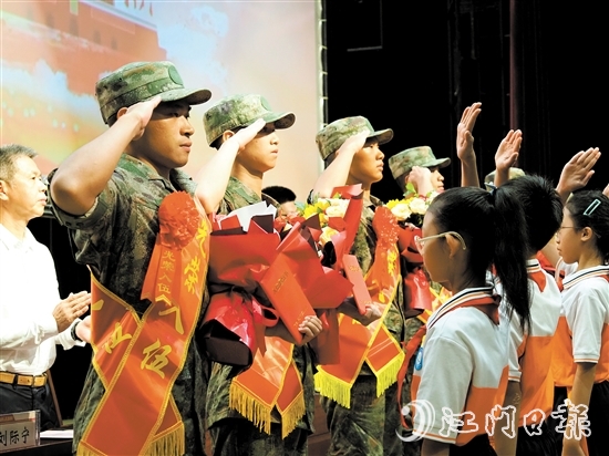 小學(xué)生代表向入伍新兵代表獻(xiàn)上鮮花。