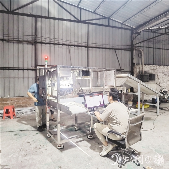 鷹視光電工作人員正在對AI視覺檢測設(shè)備進(jìn)行調(diào)試。