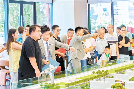 在駿景灣·品悅，銷售人員忙著為客戶介紹樓盤情況。