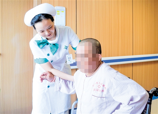 護士攙扶雙下肢無力患者上病床。