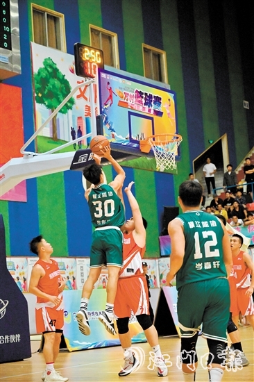 萬村籃球賽江門市級賽決賽現(xiàn)場，橫江村隊(duì)隊(duì)員迎著防守跳投得分。
