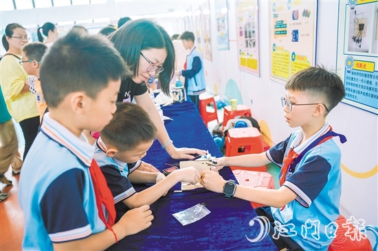 東暉小學五年級學生鄭昊宇（右）帶來了他制作的墻角照明防撞報警系統(tǒng)。