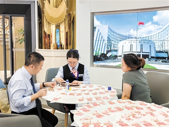 工行江門分行營業(yè)部工作人員為客戶鑒別殘幣。