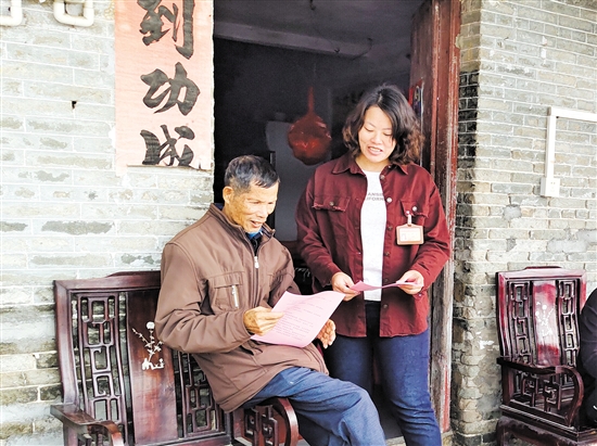 梁鳳琴（右）向群眾派發(fā)宣傳資料。