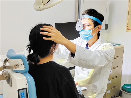 醫(yī)生為患者檢查鼻子。