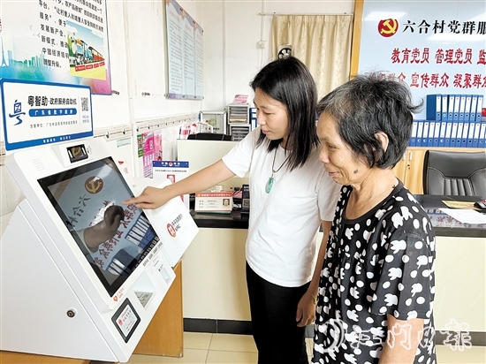 村委會干部在“粵智助”政務(wù)服務(wù)自助機上引導(dǎo)村民辦理社保業(yè)務(wù)。