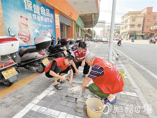 網(wǎng)格員和志愿者一同修復(fù)路面。