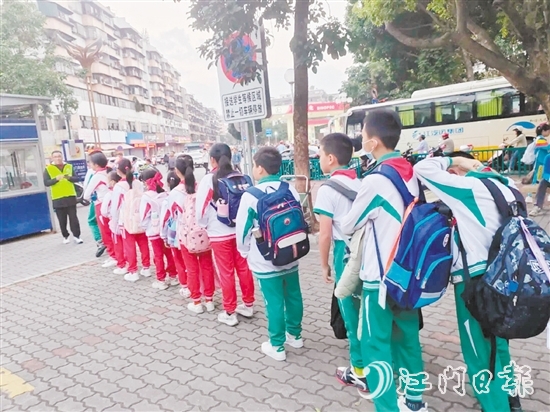 新會(huì)圭峰小學(xué)的學(xué)生有序排隊(duì)，準(zhǔn)備搭乘校園定制公交專線。