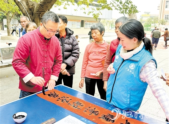 書法家手寫春聯(lián)，為群眾送祝福。