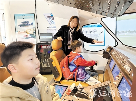 學(xué)生在工作人員的指引下體驗(yàn)中國(guó)商飛C919模擬駕駛。