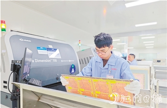 在鶴山中富生產(chǎn)車(chē)間，員工操作自動(dòng)化設(shè)備趕制電路板。