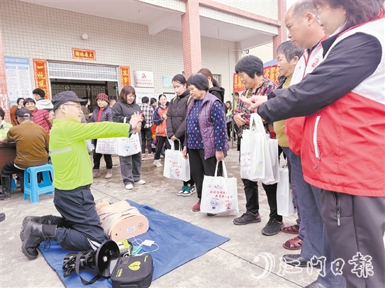 在應(yīng)急安全知識(shí)宣講攤位前，志愿者耐心講解示范急救技能，提升村民的安全意識(shí)和自救互救能力。