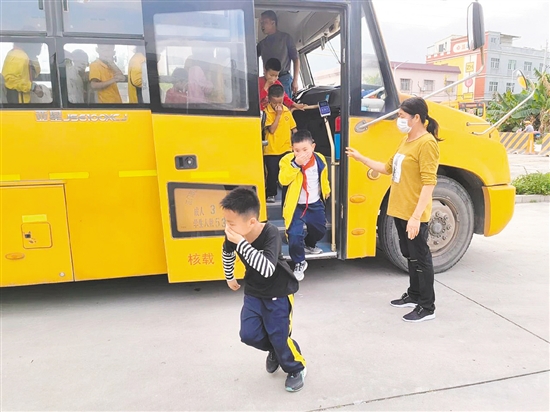 在校車應急疏散演練中，值崗教師組織學生們有序疏散，指導學生們捂住口鼻，快速撤離校車。