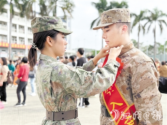 在歡送儀式現(xiàn)場，老兵姐姐為新兵弟弟整理軍裝。
