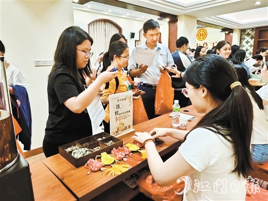 職工們與醫(yī)生探討中藥的成分和比例，制作防感驅(qū)蚊中藥香囊。