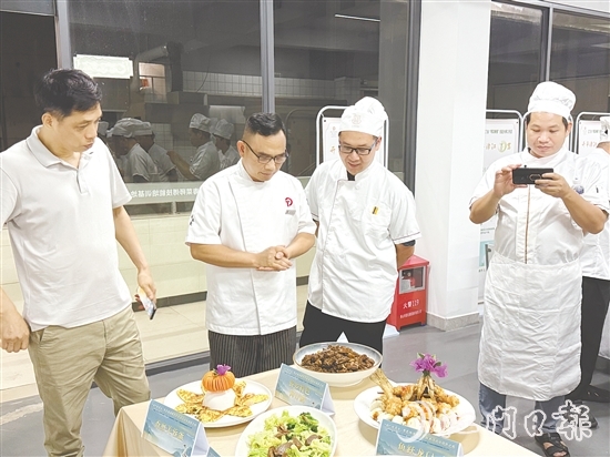 伍立更（左二）對學員們的自創(chuàng)菜式一一進行點評和指導(dǎo)。