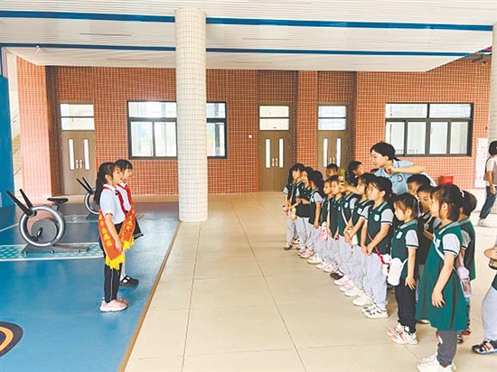 紅領(lǐng)巾講解員帶領(lǐng)孩子參觀校園。