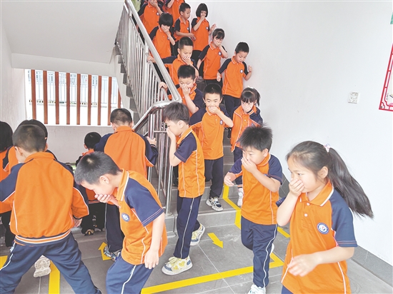 學(xué)生們彎腰低頭、捂住口鼻，按照預(yù)定路線有序撤離。