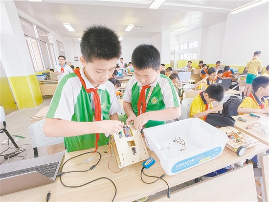 賽場上，小選手們?nèi)褙炞⒌剡M行機器人編程與調(diào)試。