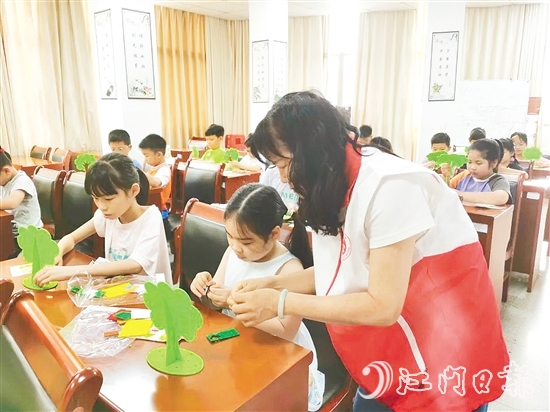 孩子們在志愿者的示范和指導下，精心制作“家庭樹”。