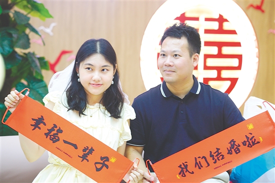 “520”迎來婚姻登記熱潮，在蓬江區(qū)、江海區(qū)的婚姻登記處，新人拍照留念。江門日報記者