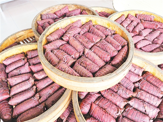 文龍?zhí)鹌肤兆拥曛谱鞯蔫潘疹仾毺?，粽葉呈現(xiàn)紫紅色。