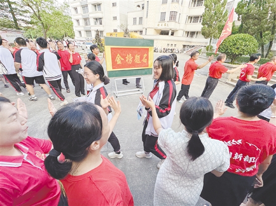 臺(tái)山一中在送考路上設(shè)置了“金榜題名”大字帖，教師身穿紅衣與學(xué)生擊掌，為學(xué)生加油。
