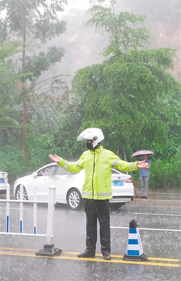 高考期間，交警在大雨中維持交通秩序。