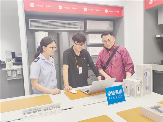 稅務(wù)部門輔導(dǎo)小米之家工作人員為旅客開具退稅申請單。