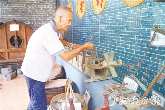新華村打造農(nóng)耕文化展館，留住鄉(xiāng)村記憶。圖為村中老人向記者介紹農(nóng)具。