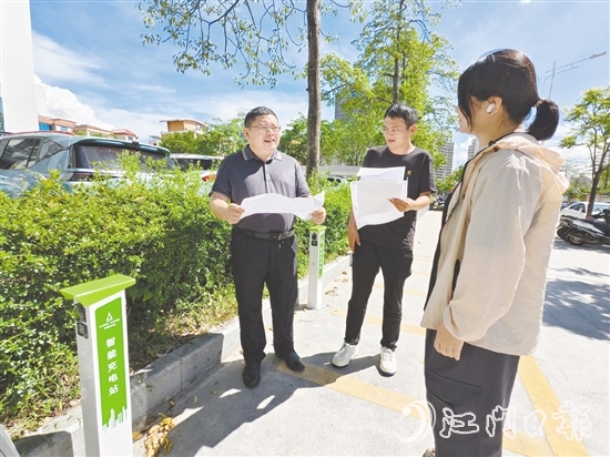 余中宏（左一）與同事一起查看“民生服務(wù)充電站”項(xiàng)目建設(shè)進(jìn)度。