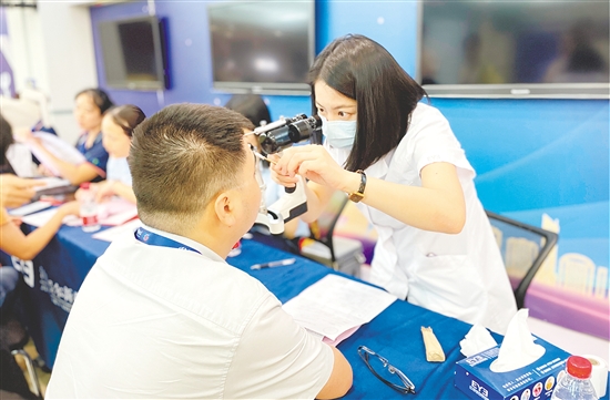 醫(yī)護人員為企業(yè)職工檢查眼睛。
