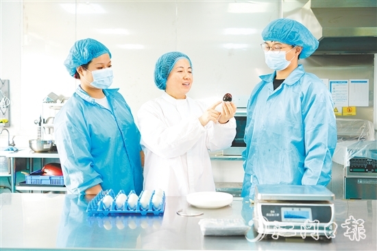 在培訓(xùn)室里，梁艷芬（中間白衣）和大家交流蛋品檢測方式。