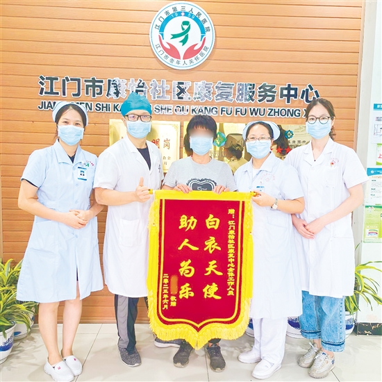 李明給康復中心醫(yī)護人員送上錦旗。