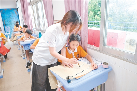 社會(huì)實(shí)踐隊(duì)隊(duì)員指導(dǎo)學(xué)生練習(xí)硬筆、軟筆書法。