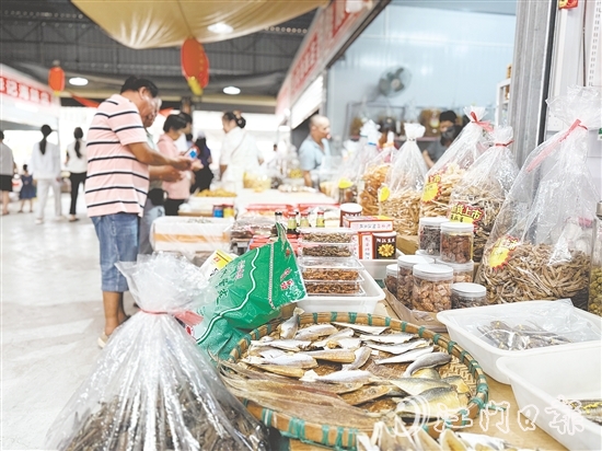 游客紛紛到海鮮特產(chǎn)市場挑選海味。