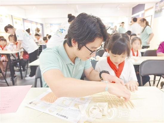 學生志愿者耐心教導孩子制作手工。
