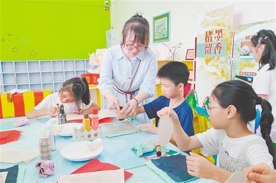 在導(dǎo)師的指導(dǎo)下，孩子們紛紛拿起紙張，在拓板上謹(jǐn)慎操作。