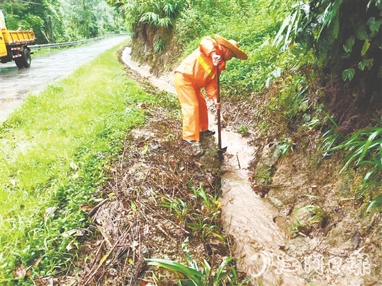 道路養(yǎng)護(hù)人員清理被泥沙落葉堵塞的邊溝涵洞，確保雨水快速排走。