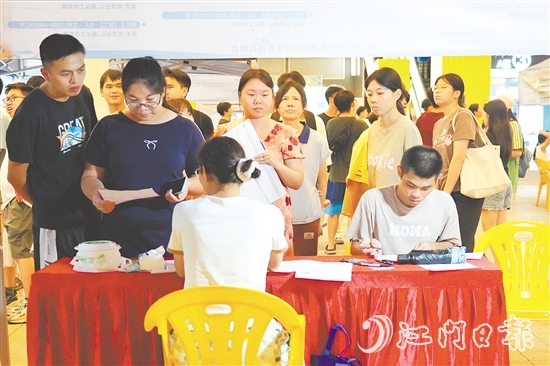 活動現(xiàn)場，求職者手持簡歷與企業(yè)招聘人員進行交流。