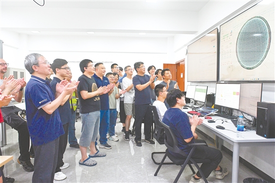 8月26日，科研人員在江門中微子實驗運行控制室共同開啟物理取數(shù)，鼓掌慶祝取數(shù)成功。