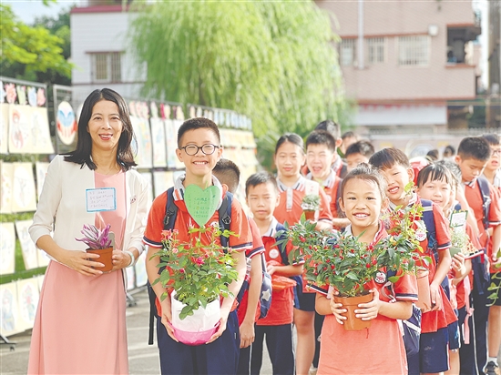 新民小學同學們各自手捧暑假期間的種植成果返校。