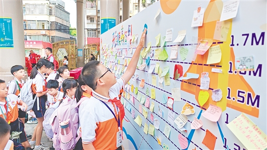 沙坪街道第一小學設立“開學摸高簽到墻”，學生貼上寫有新學期愿望的“心愿卡”。