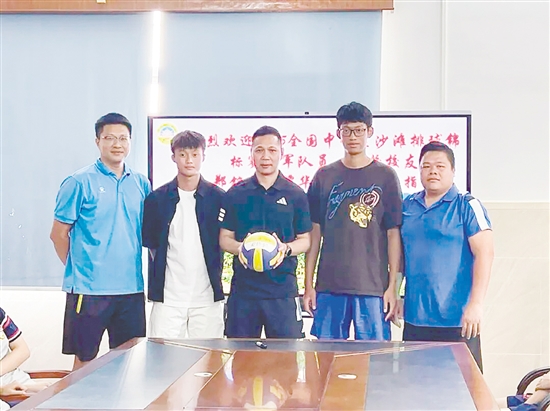 鄭銘毅（左二）與譚華鋒（右二）將親筆簽名的排球贈予母校。