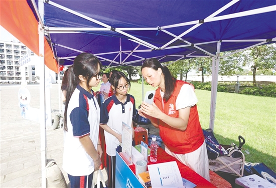 工作人員向新入學(xué)學(xué)生介紹醫(yī)保線上辦事流程。